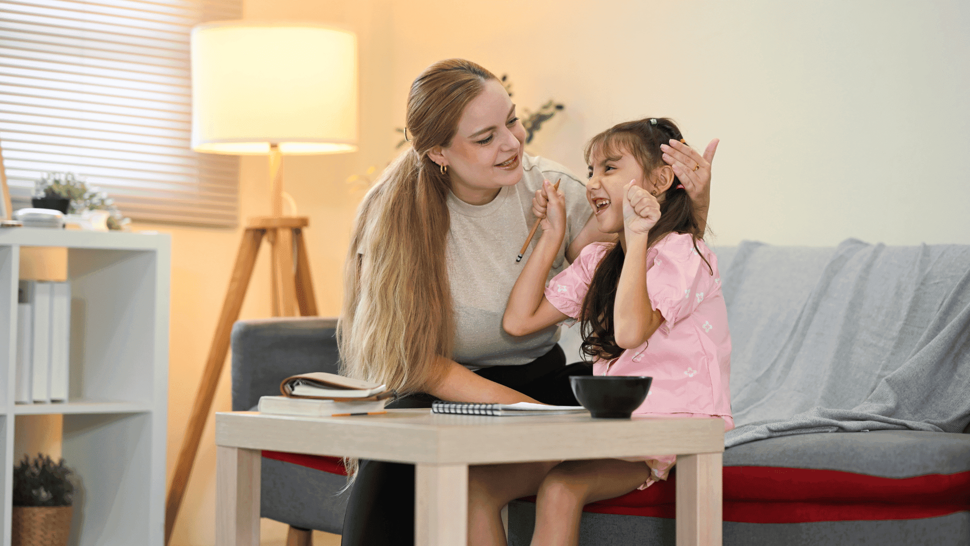 A mother and daughter sitting on a sofa, talking to each other, with the daughter smiling while describing HushAway®’s Sound Sanctuary.