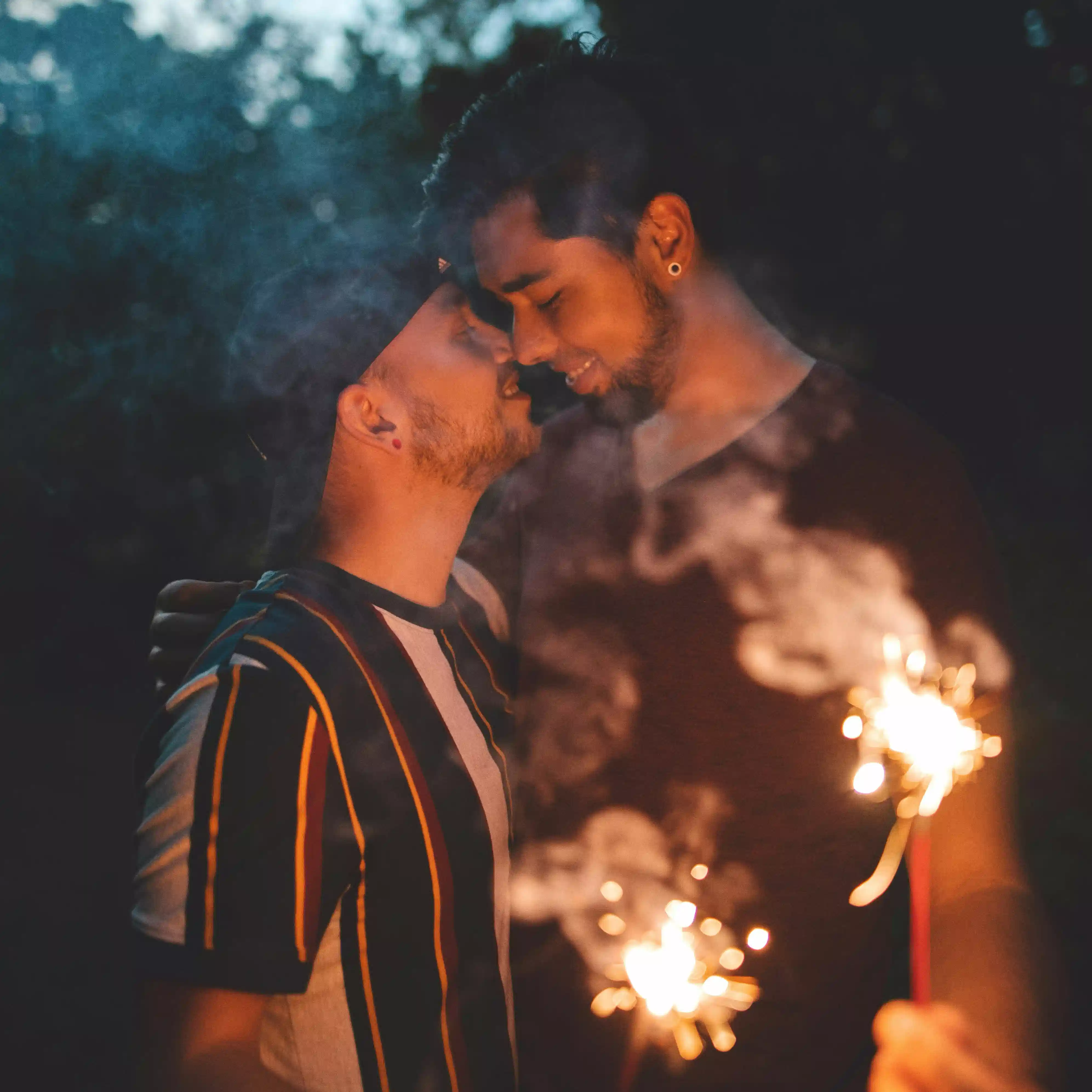 LGBTQ couple sharing a warm, intimate moment with sparklers, symbolizing love, connection, and hope through couples counseling in Los Angeles.