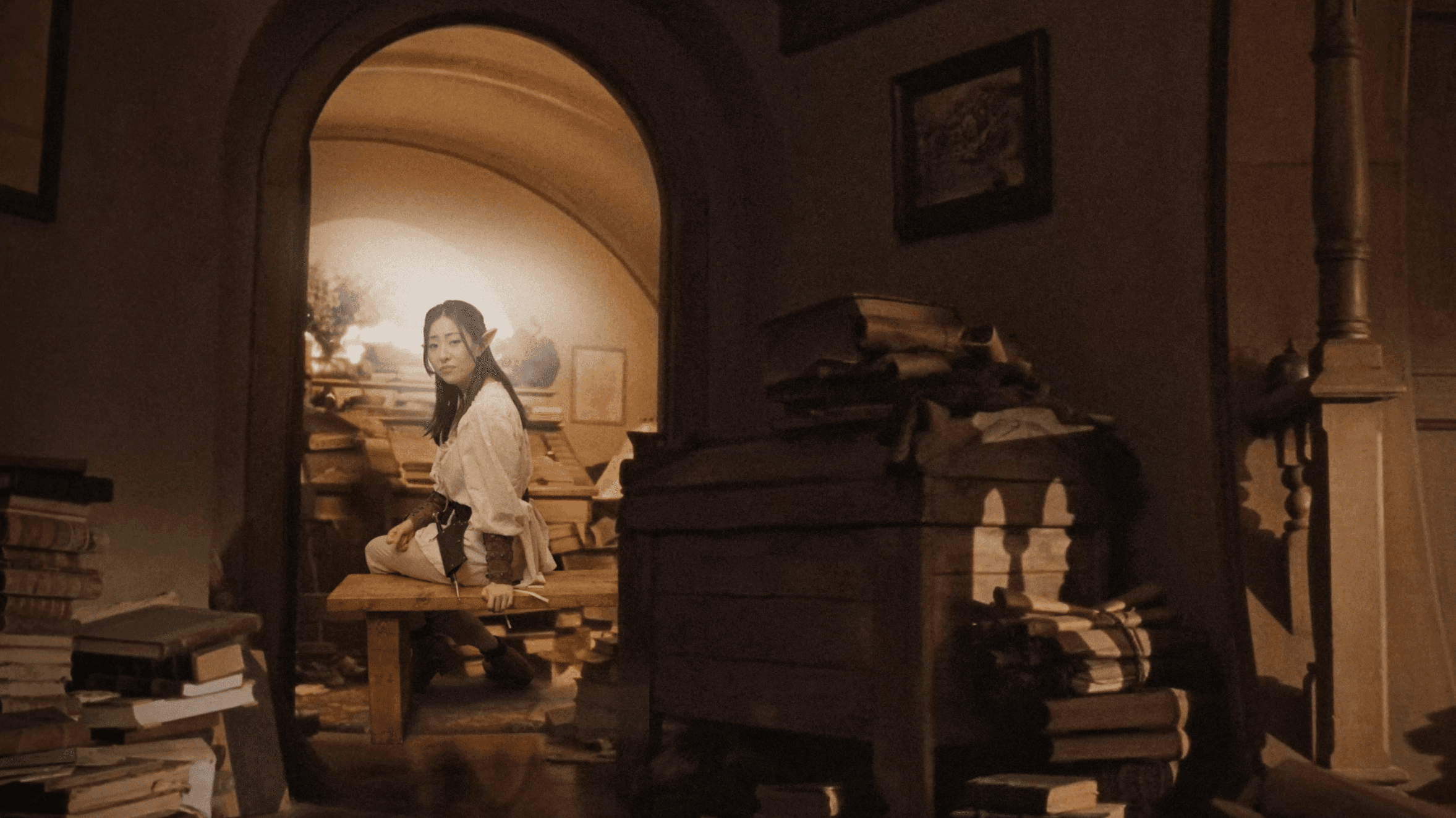 A study interior with books, drawings and a low arched ceiling.
