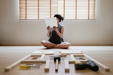A person putting together an IKEA bed set
