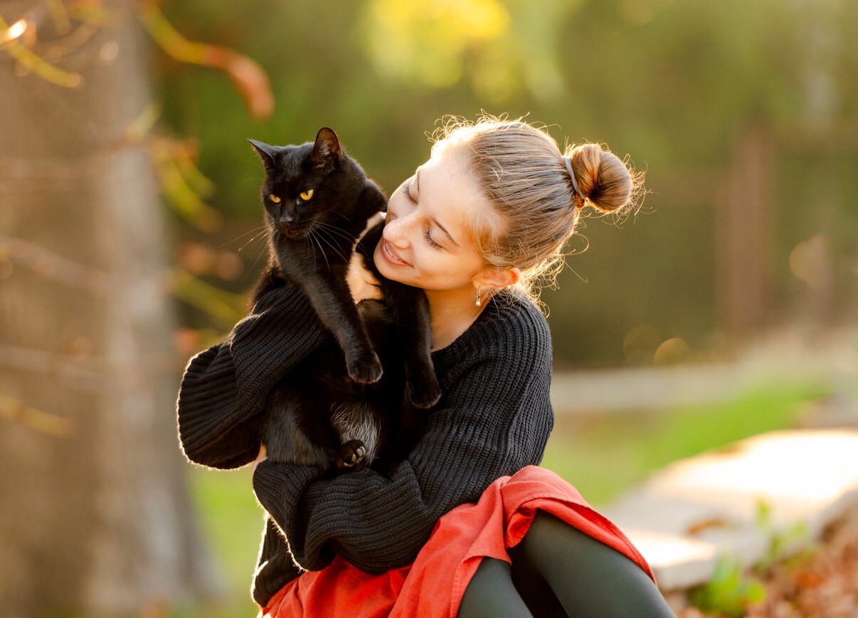 girl outdoors with black cat