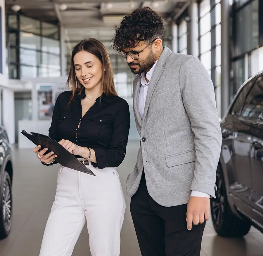 Customer consulting with collision repair specialist about insurance claim in auto body shop