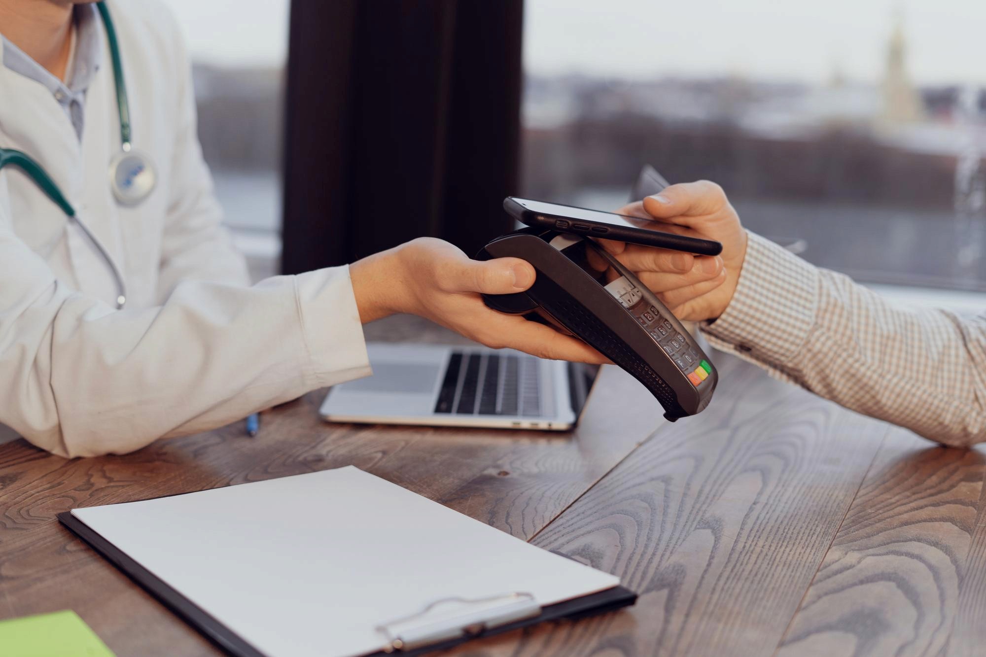 Smiling Black man using smartphone and listening to music with wireless earbuds while lying in bed.