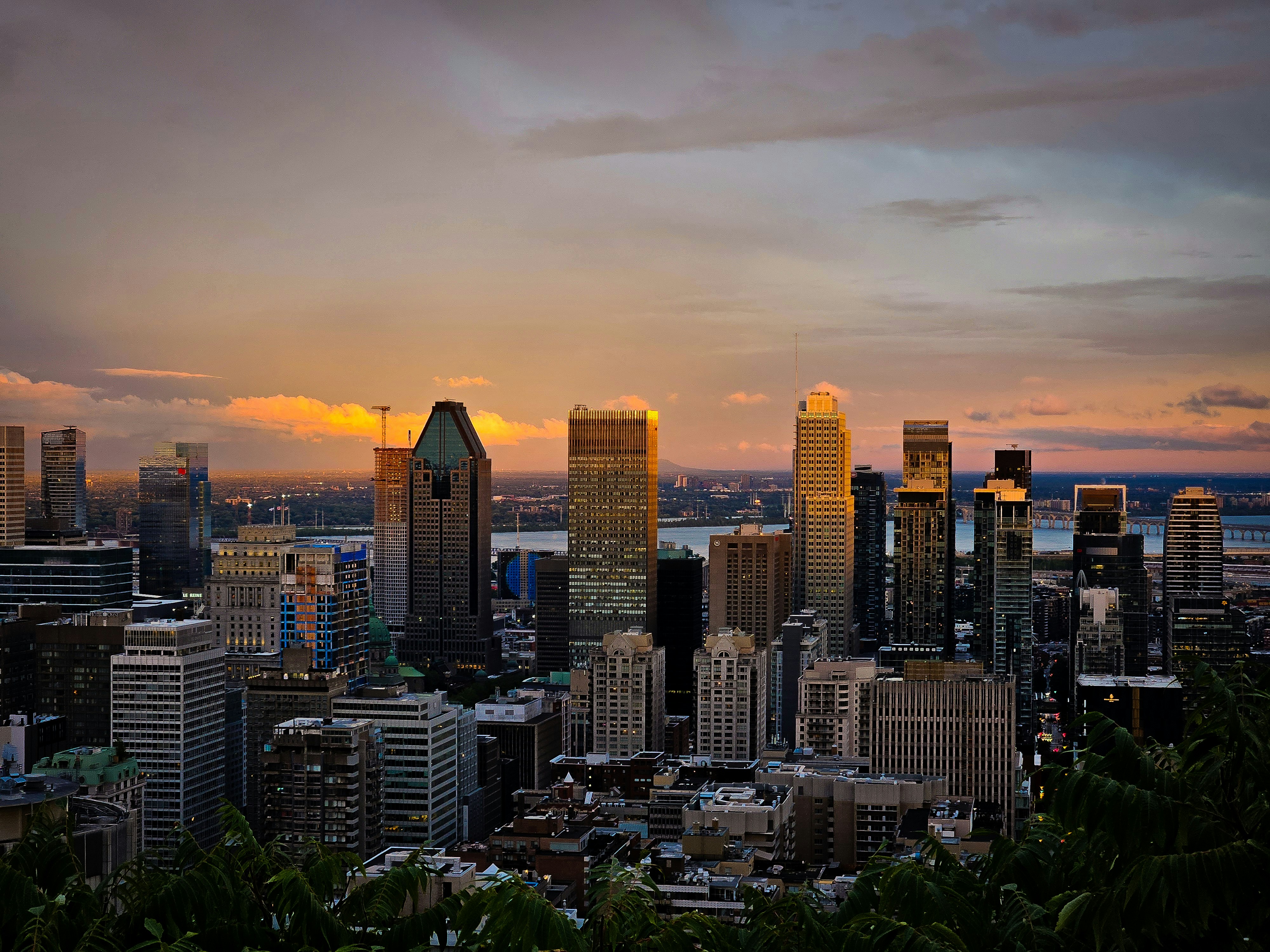 A view of a city at sunset from the top of a hill