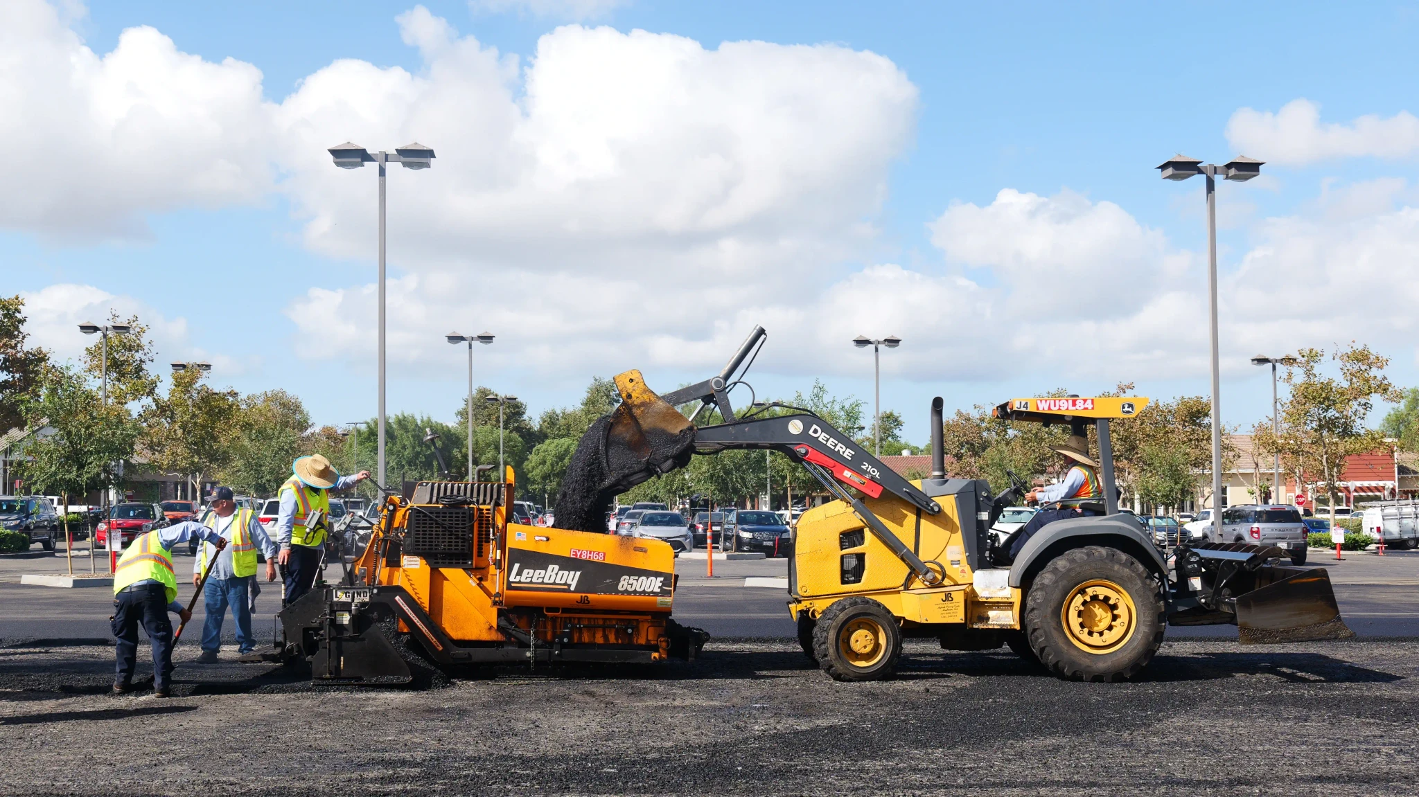 Equipment loading asphalt hot mix into paving machine