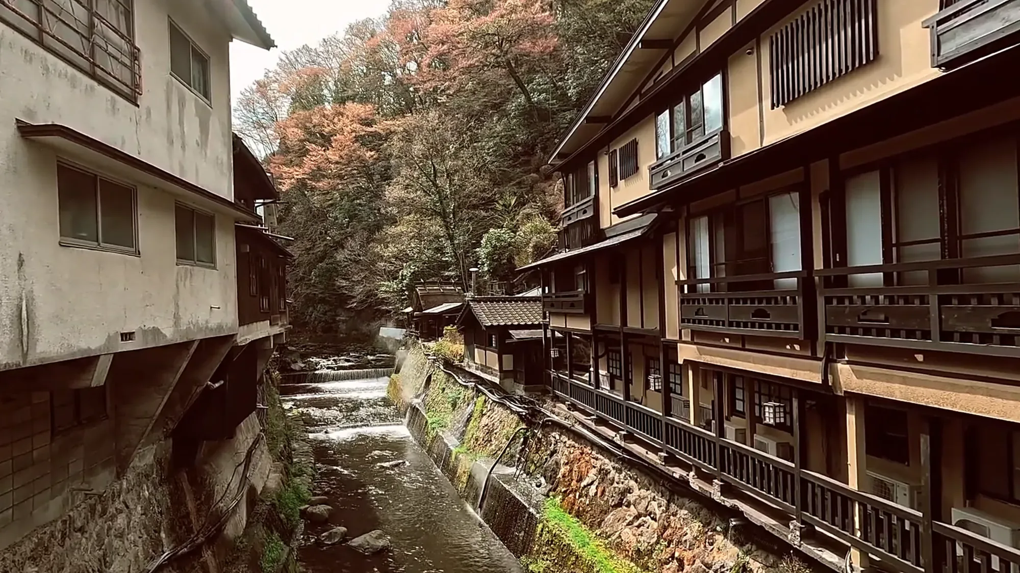 A narrow stretch of river between tall timber inns at Kurokawa Onsen