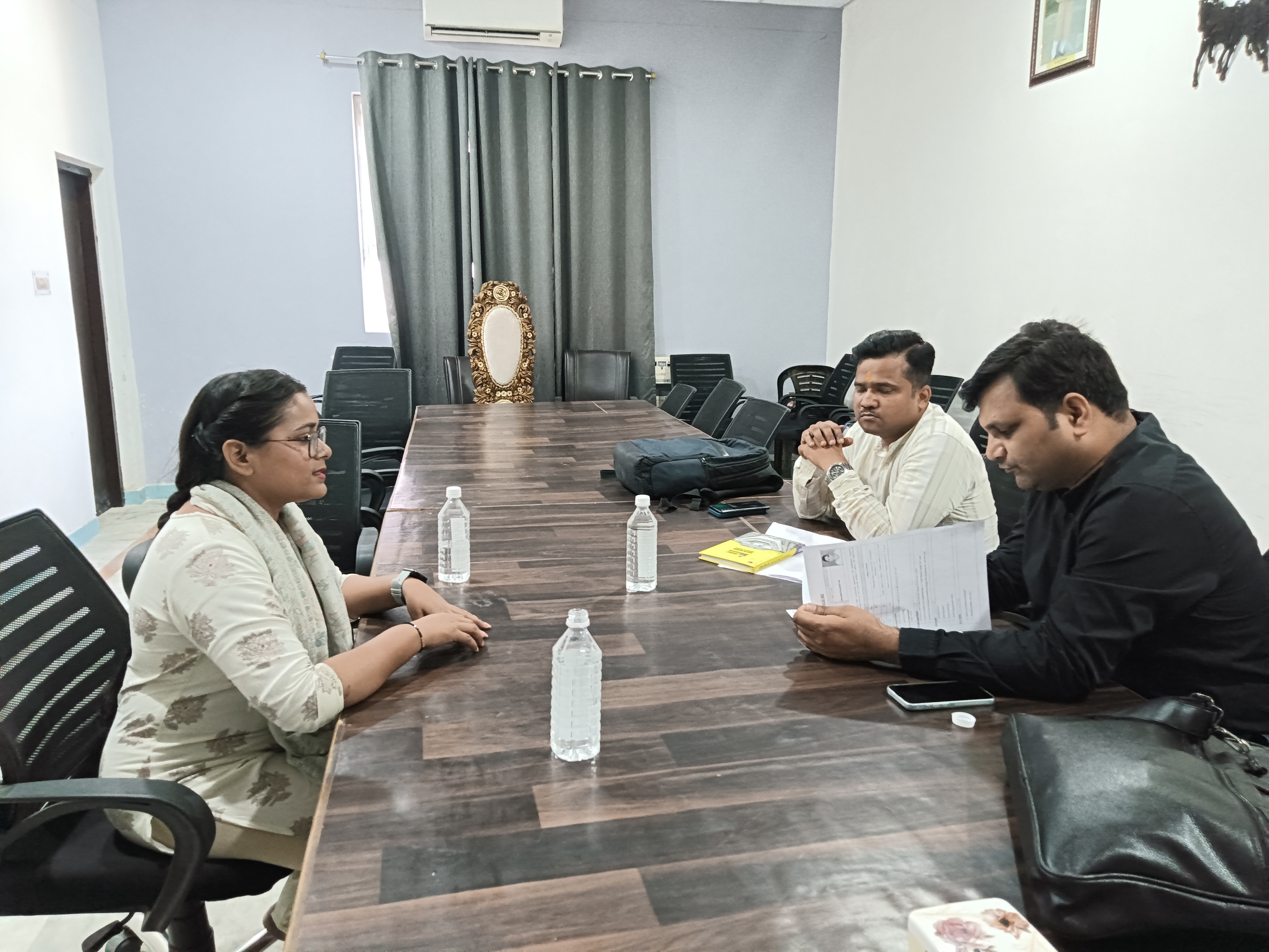 people sitting on chair in front of table while holding pens during daytime