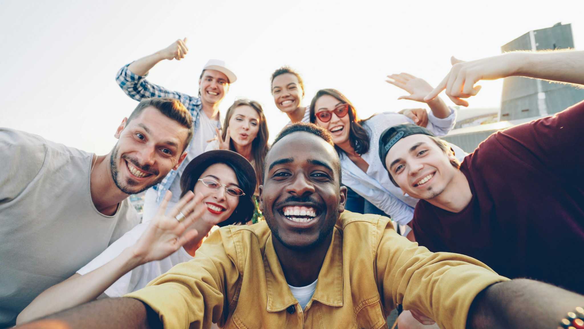 Um grupo diversificado de amigos felizes tirando uma selfie