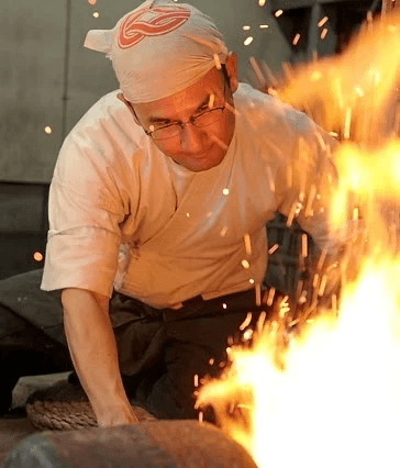 Swordsmiths hammering iron in a team