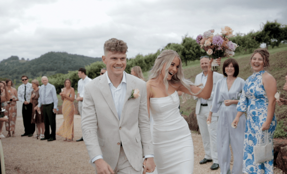 wedding ceremony with bride and groom between palm trees