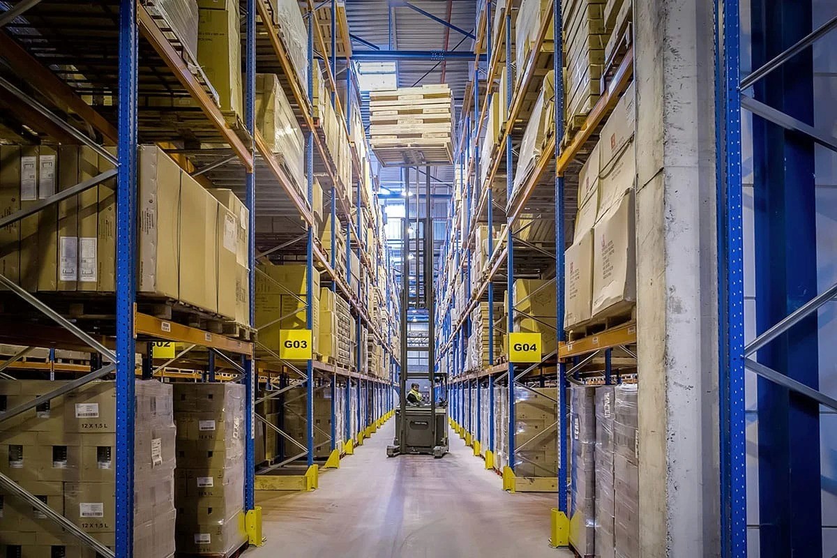Allée d’entrepôt logistique avec rayonnages métalliques — photographe industriel Lille | Anteale Yann Manac’h 2025