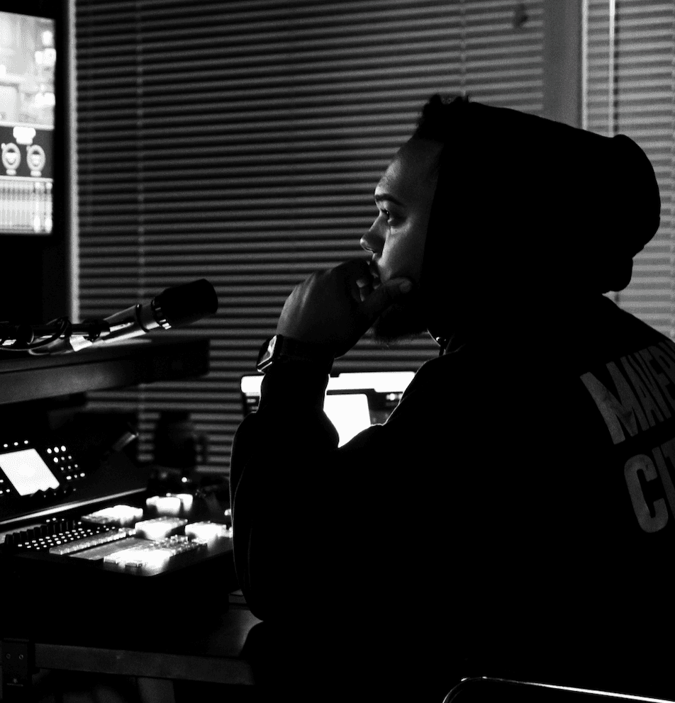 a person wearing a helmet and a cloak with a plain gradient background