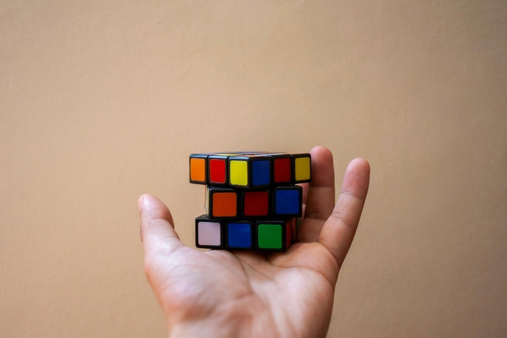 Cubo de Rubik en una mano como metáfora de la eficiencia en el uso de activos