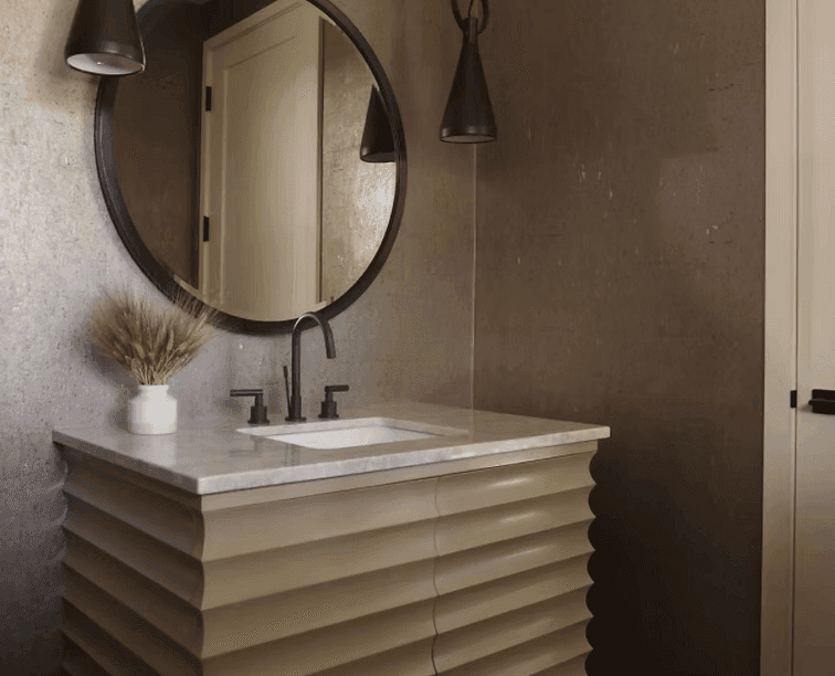 A person with short blonde hair holds a vintage camera.