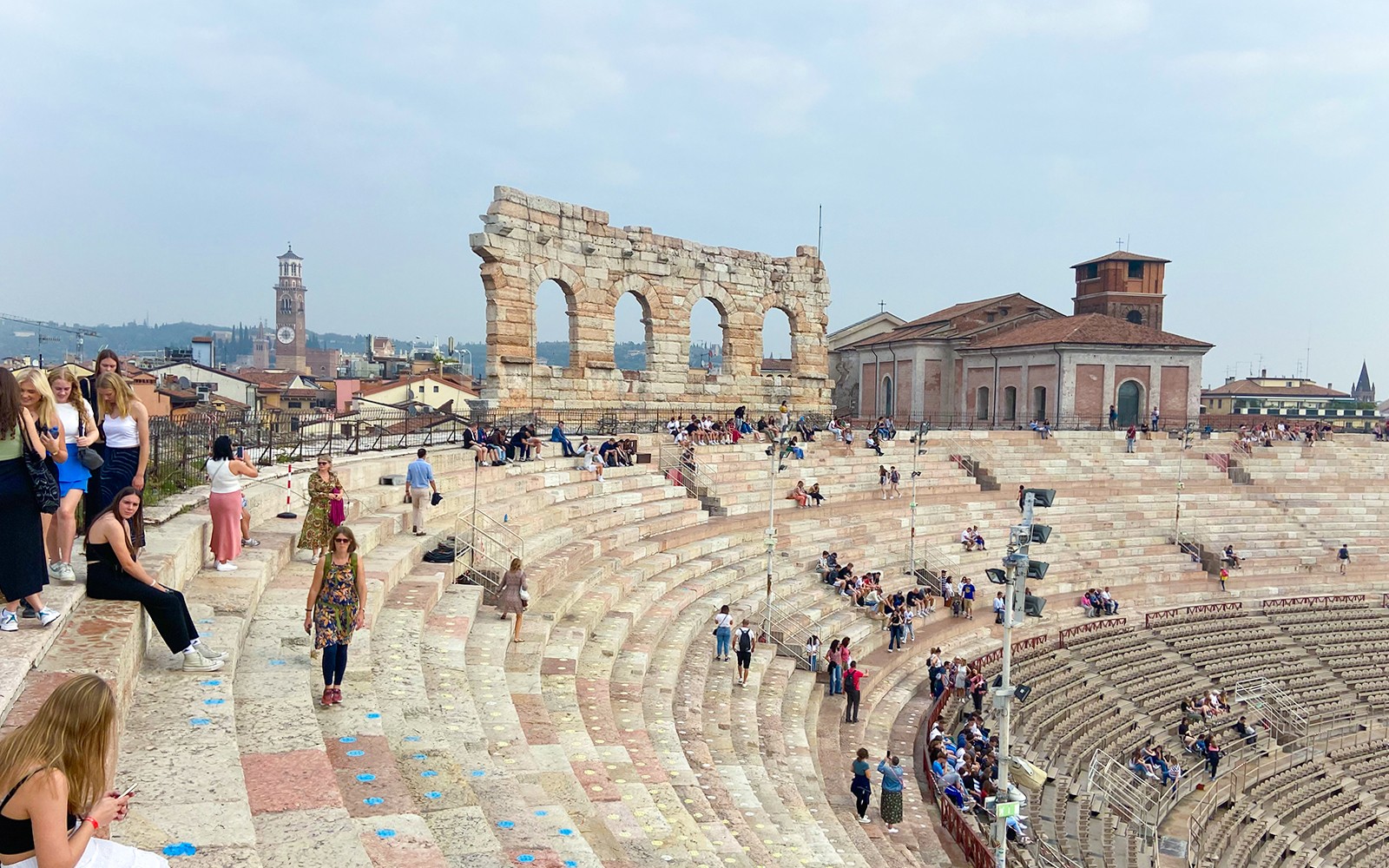 Arény Verona, kde návštěvníci sedí na starobylých kamenných schodech.