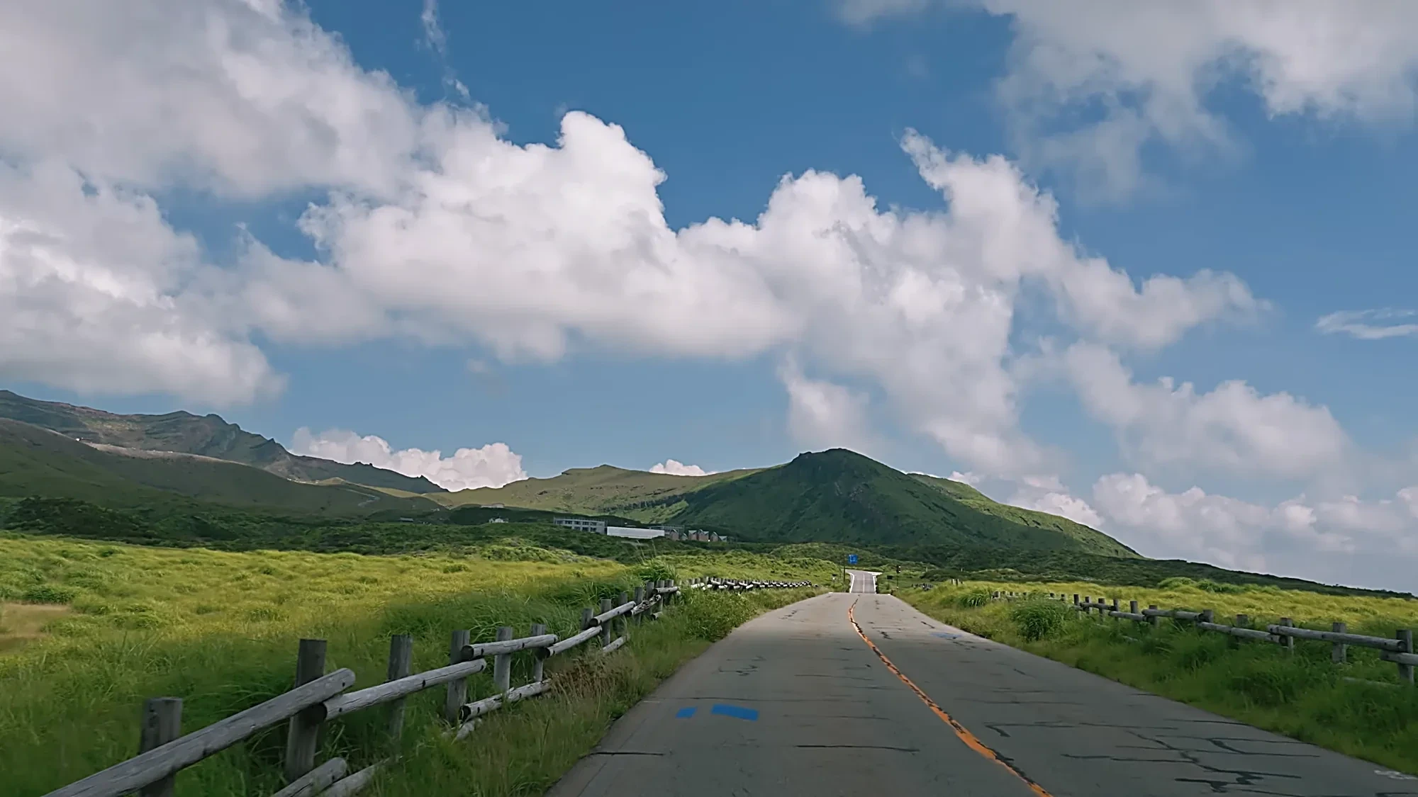 A road running straight across the Aso grassland on the approach to Kurokawa Onsen