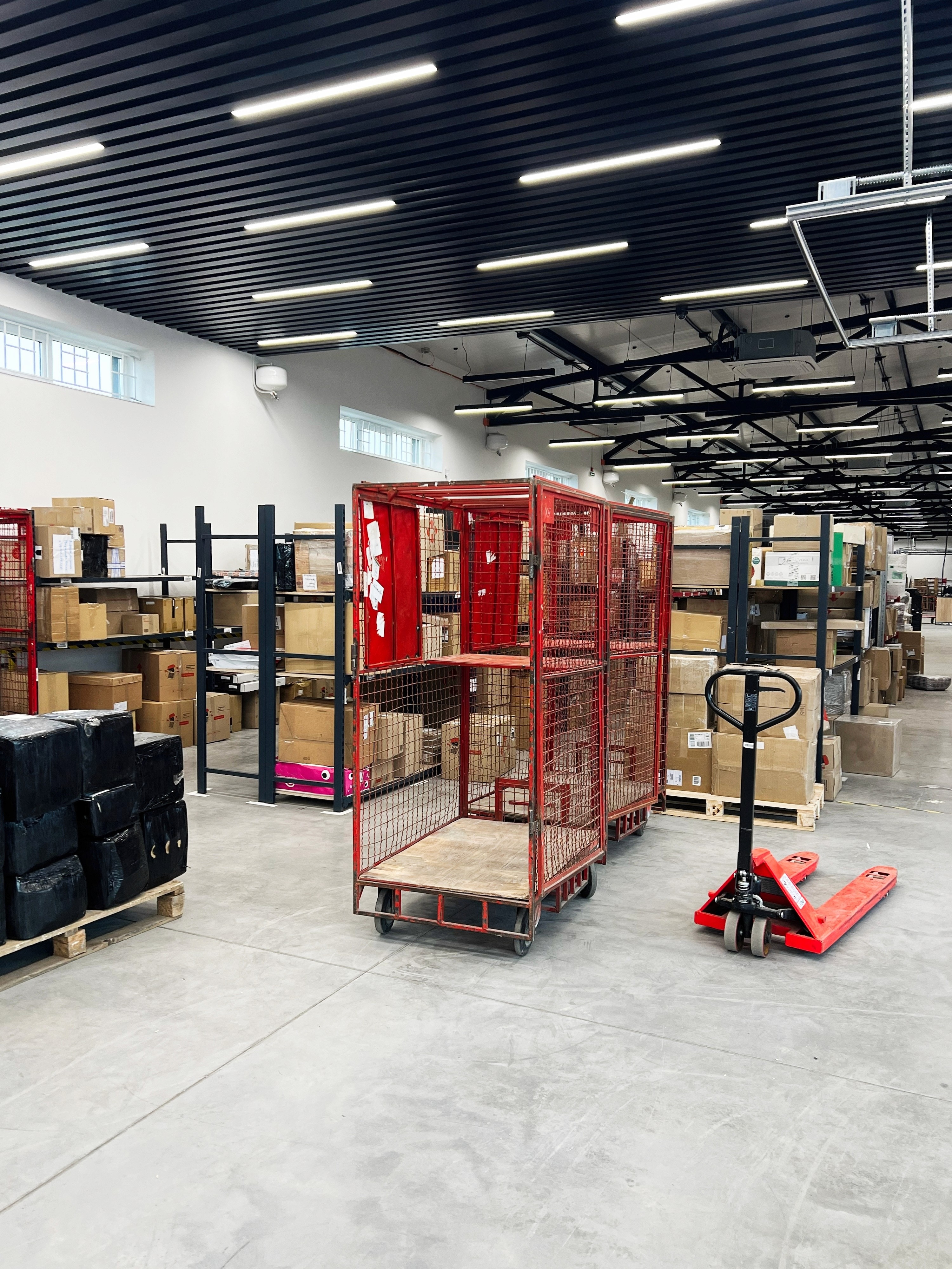 A warehouse storage shelving unit filled with boxes and pallets by ARENA Storage
