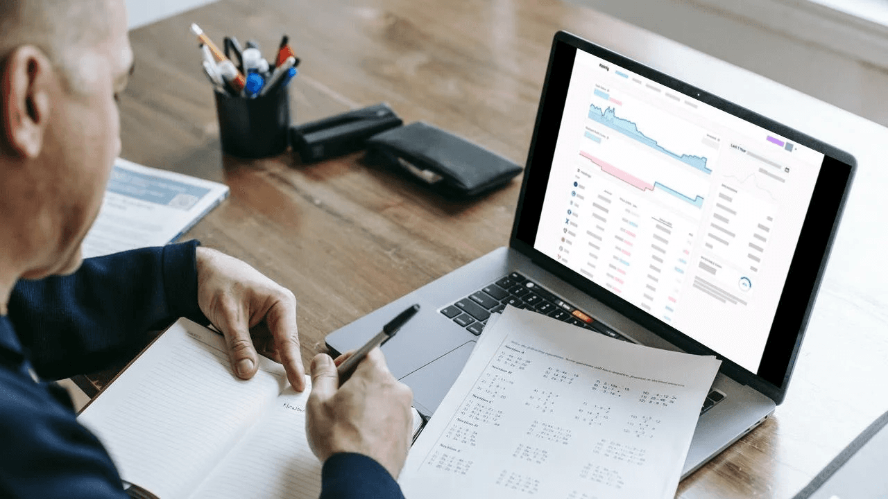 Man working at laptop and notebook - Do You Pay Taxes on Crypto Before Withdrawal