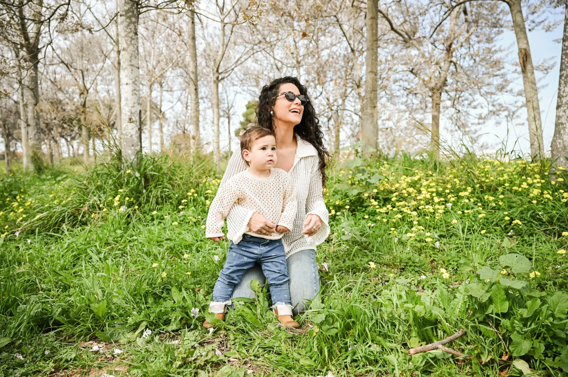 צילום משפחה רך וטבעי בשדה פורח, אם וילד באור יום נעים. צילום לייף סטייל מקצועי של הצלמת שירי עציץ Shiriz המדגיש רגעים של אושר וחיבור בטבע.