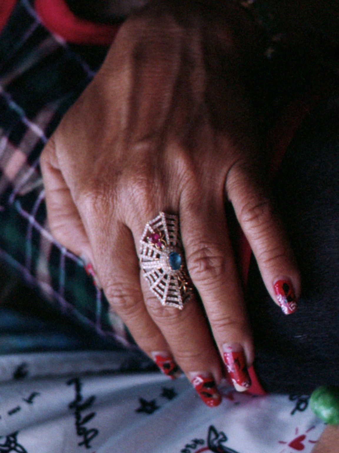 "Hand resting on a leg with a ring on the middle finger"