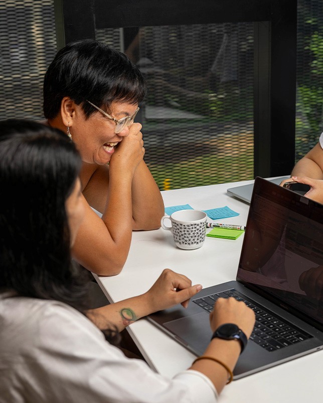 An image of a few 55 Minutes' members having a discussion around the table at the office.