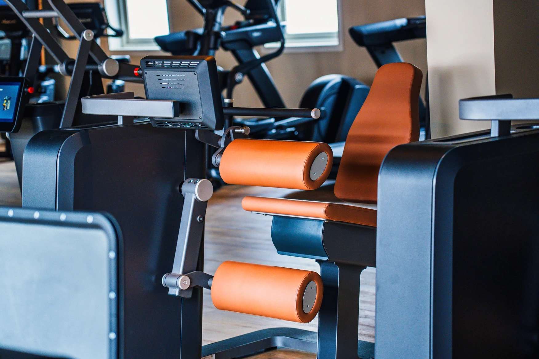 Detail van een premium krachtmachine met oranje bekleding bij Bodywork Scherpenzeel