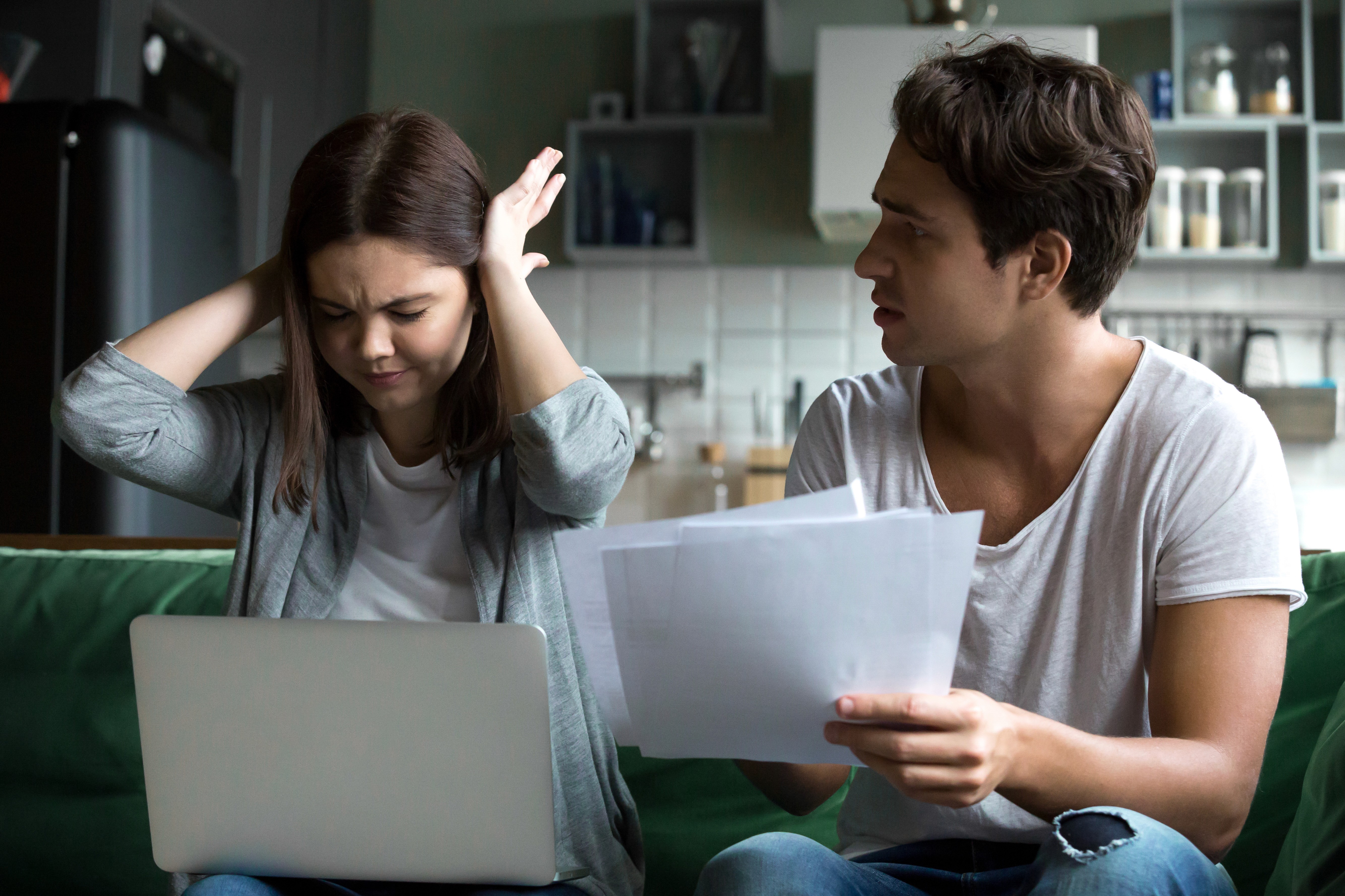 Stressed couple reviewing documents reflects customer frustration caused by misleading product claims, unclear pricing, and lack of transparency in online shopping.