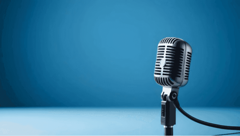 A single microphone in front of a blue background