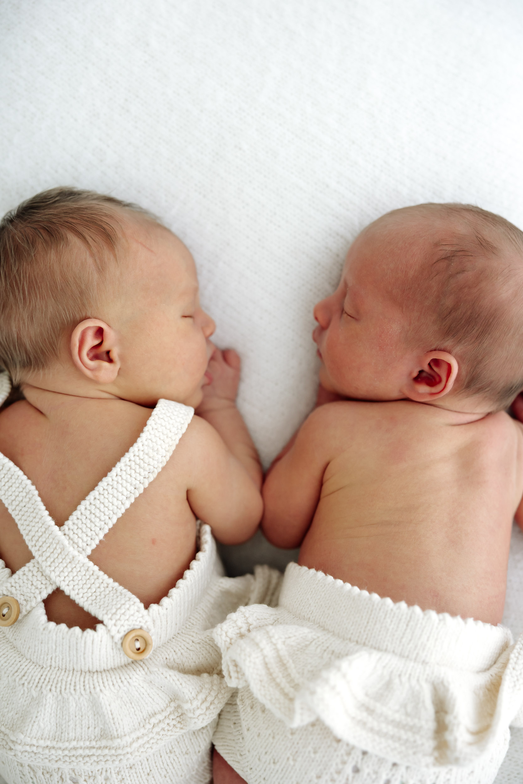 Studio newborn photos of twins in Mackay, newborn siblings posed together in natural light with minimalist styling.