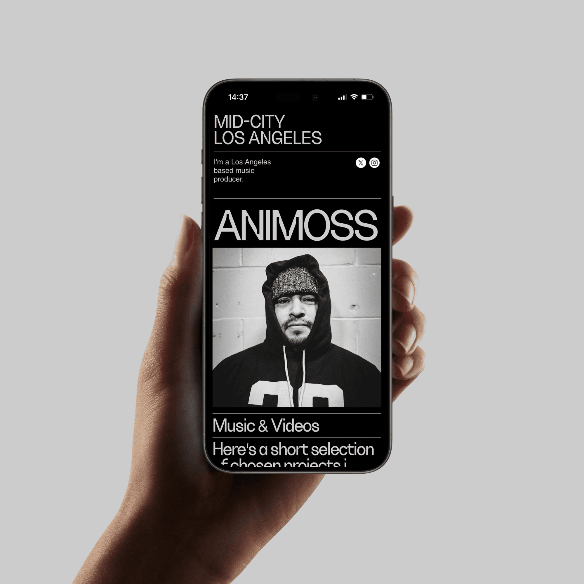 A hand holding a Iphone device showing the website's mobile version