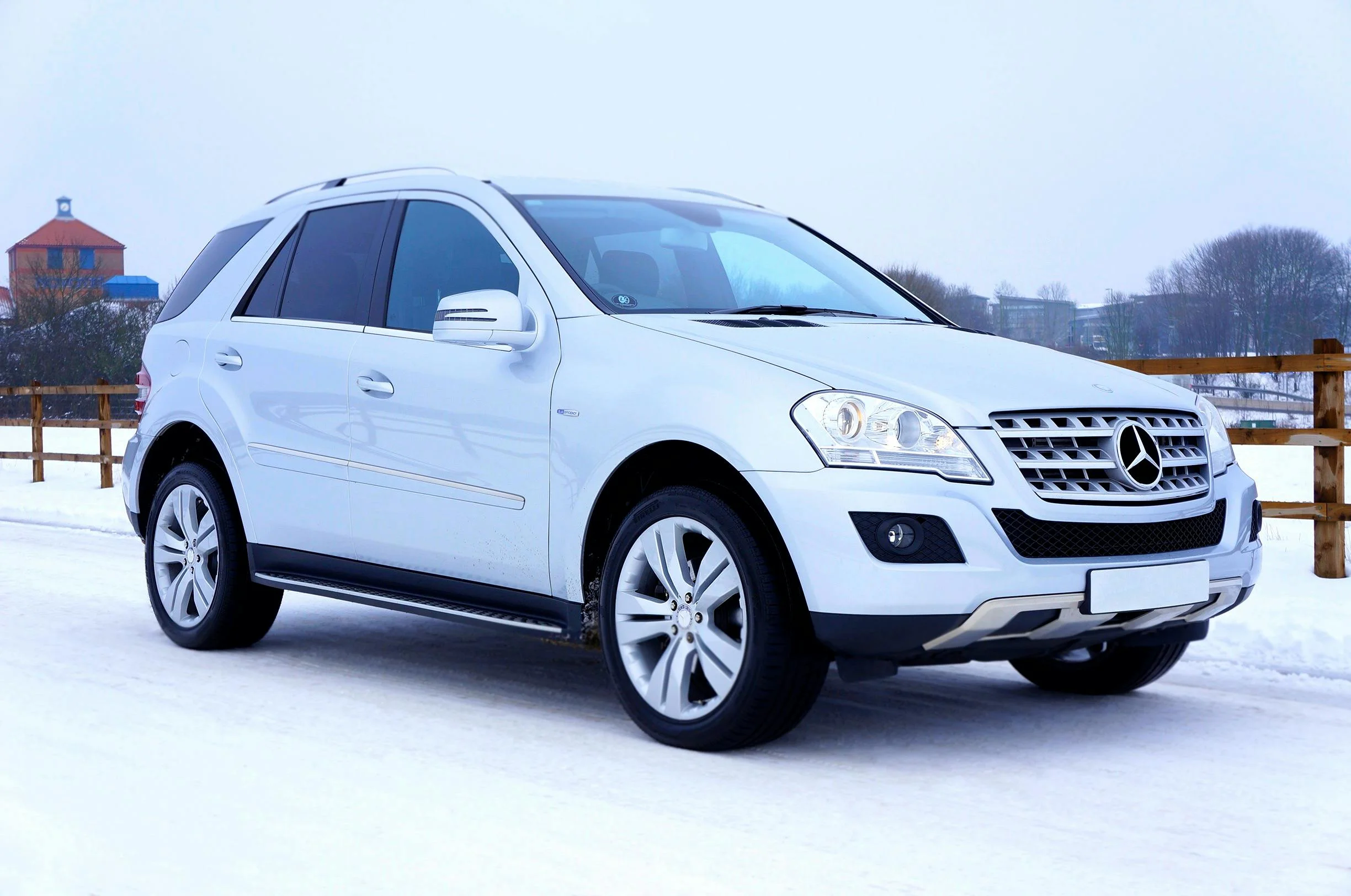 SUV blanc circulant sur route enneigée, symbole de robustesse, sécurité et performance dans toutes les conditions. 