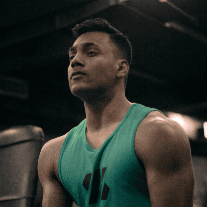 A man with a serious expression in a gym, wearing a green tank top. Text: Lucas Ward – Fitness Specialist.