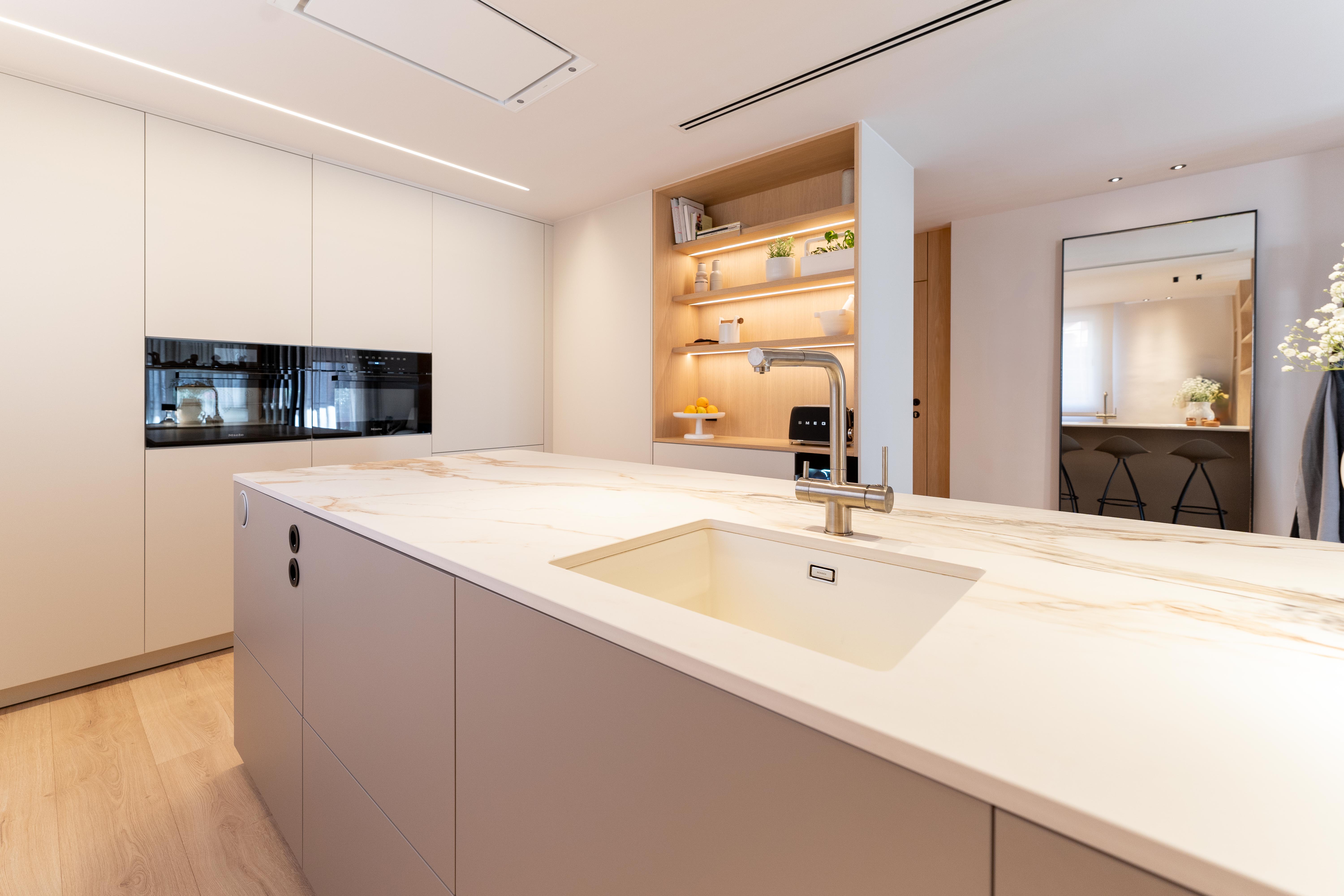 Cocina con muebles blancos y encimera de cocina con mármol blanco