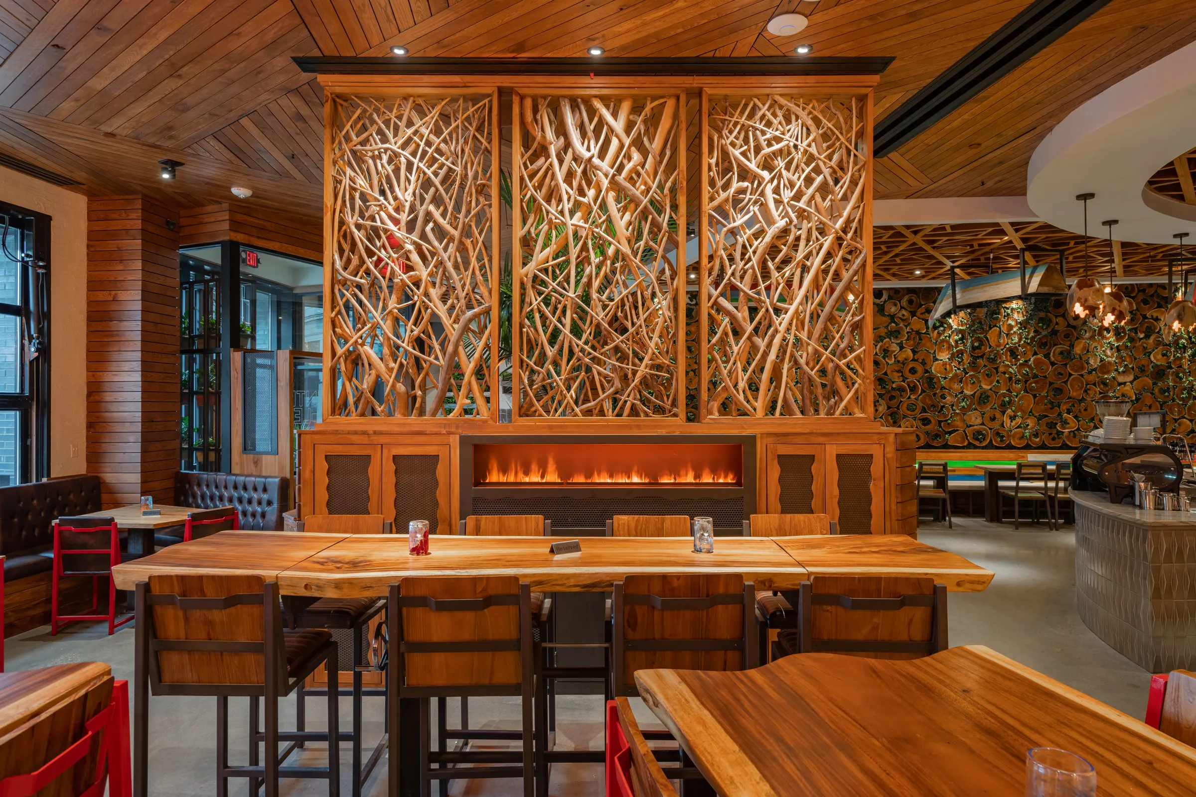 Communal high-top table by a fireplace and branch screen at TownHall Columbus