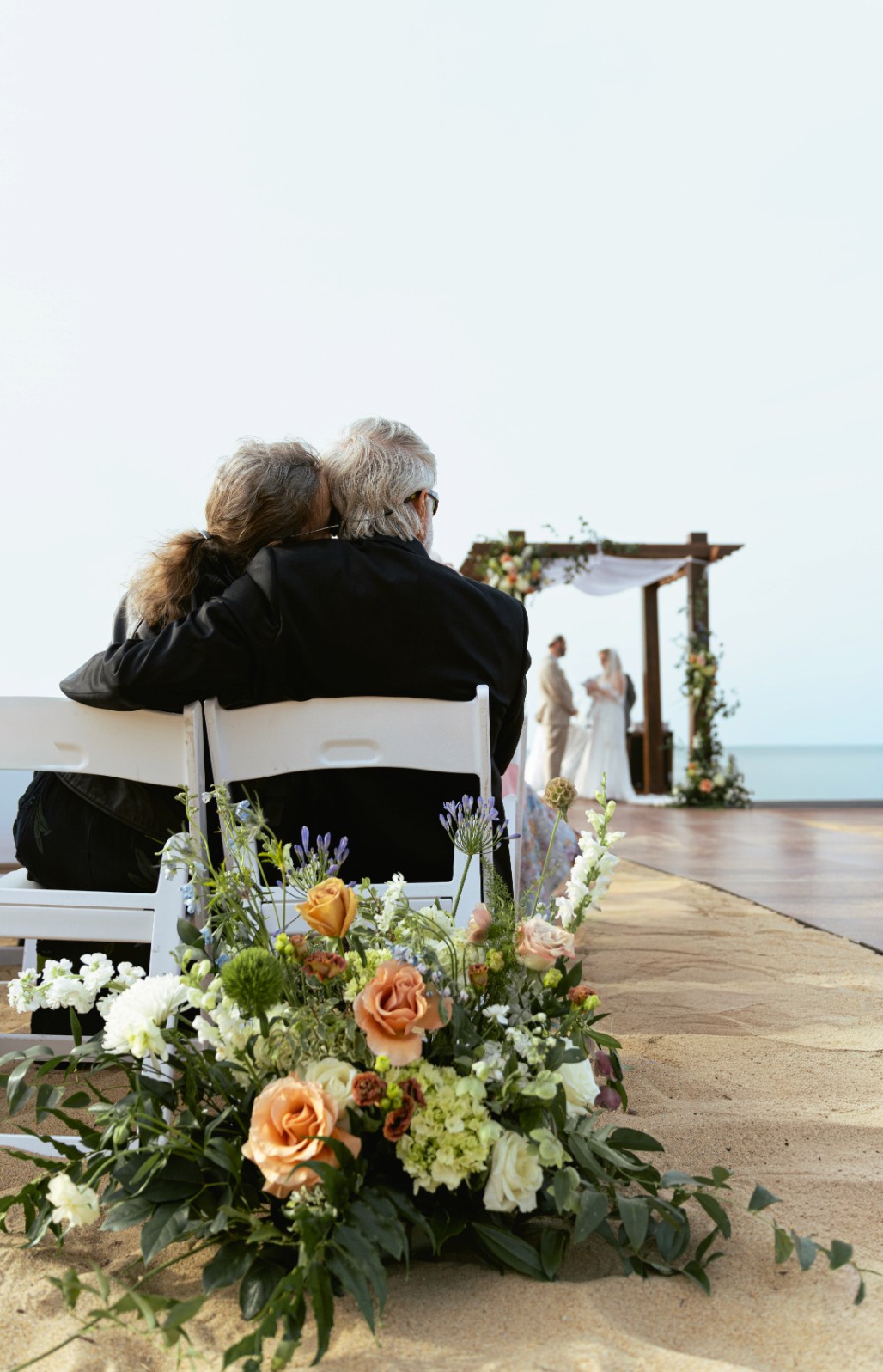 A couple stands outdoors at sunset.
