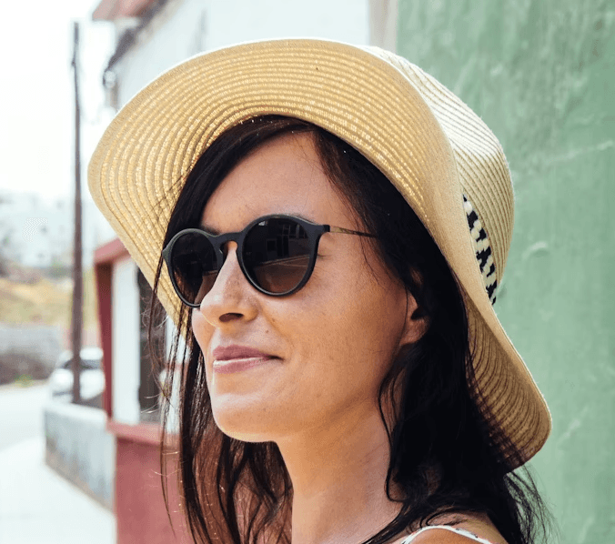 a young man wearing glasses standing in front of a mountain