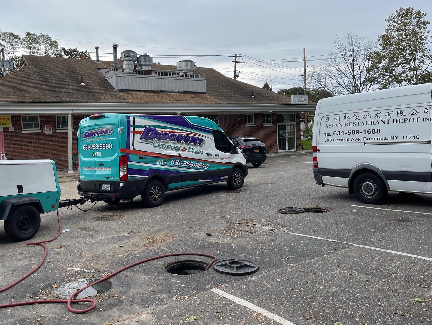 Discount Cesspool & Drain service trucks at a Long Island business