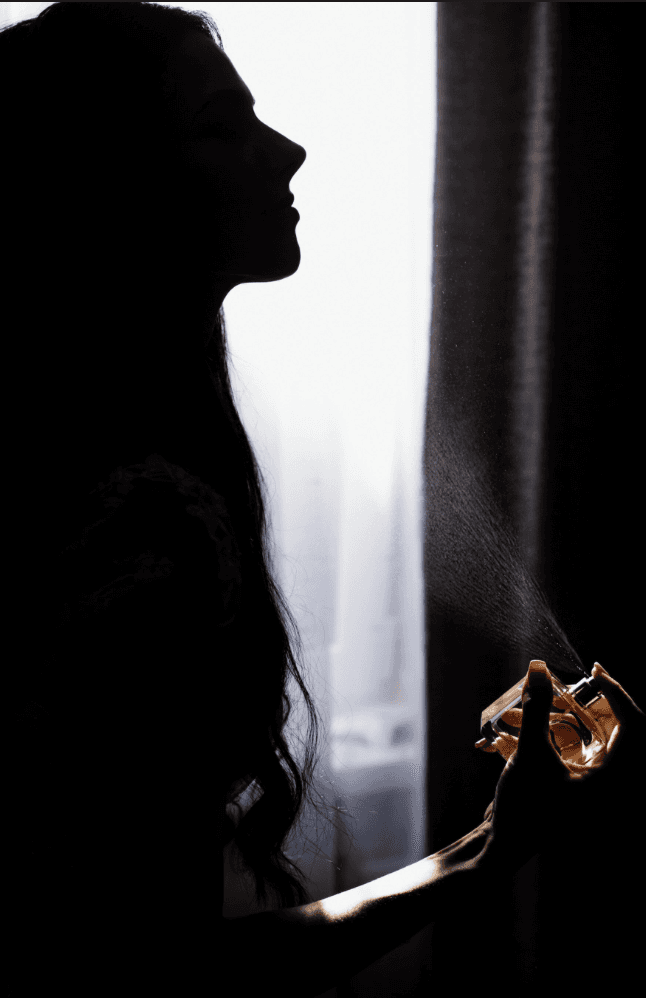 woman spraying perfume fragrance