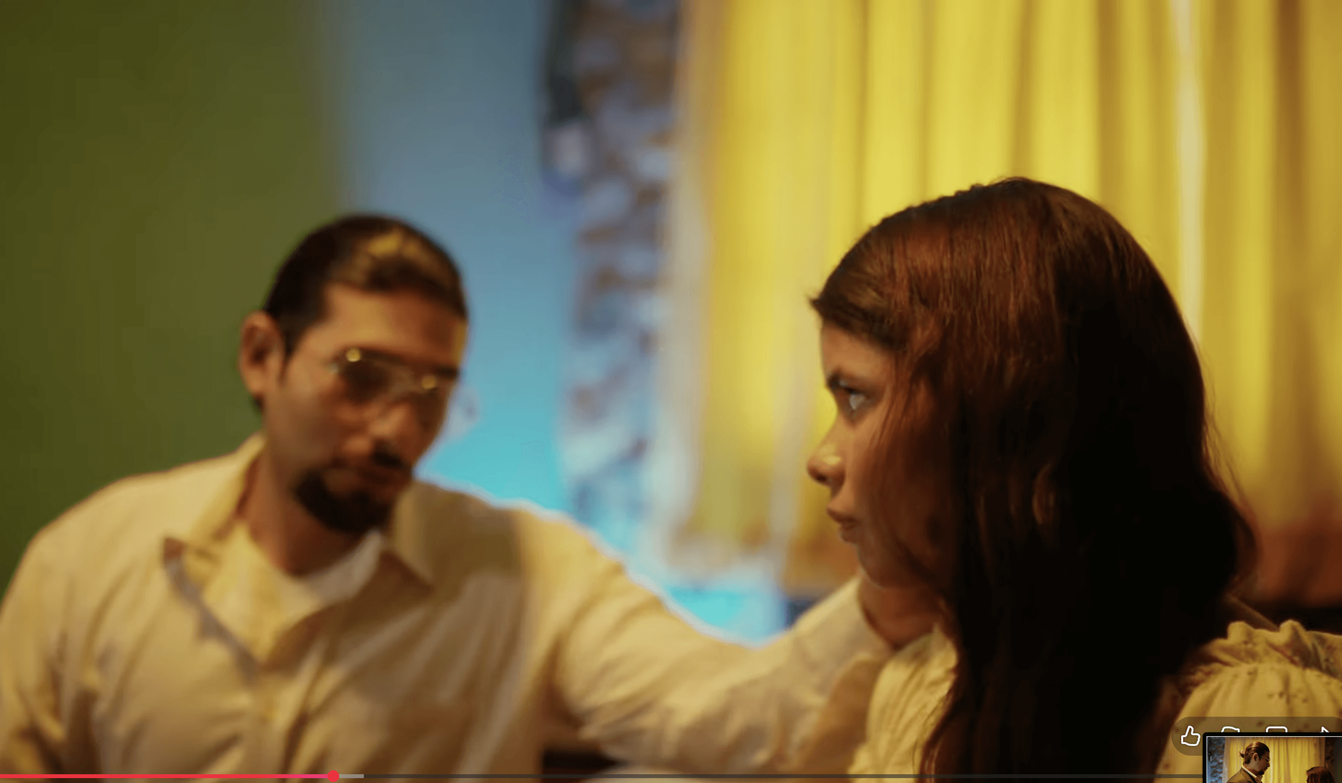 View of the French countryside through a stone villa’s open living room, with sofas and trees framing the scene