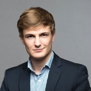 a man with a goatee smiles at the camera