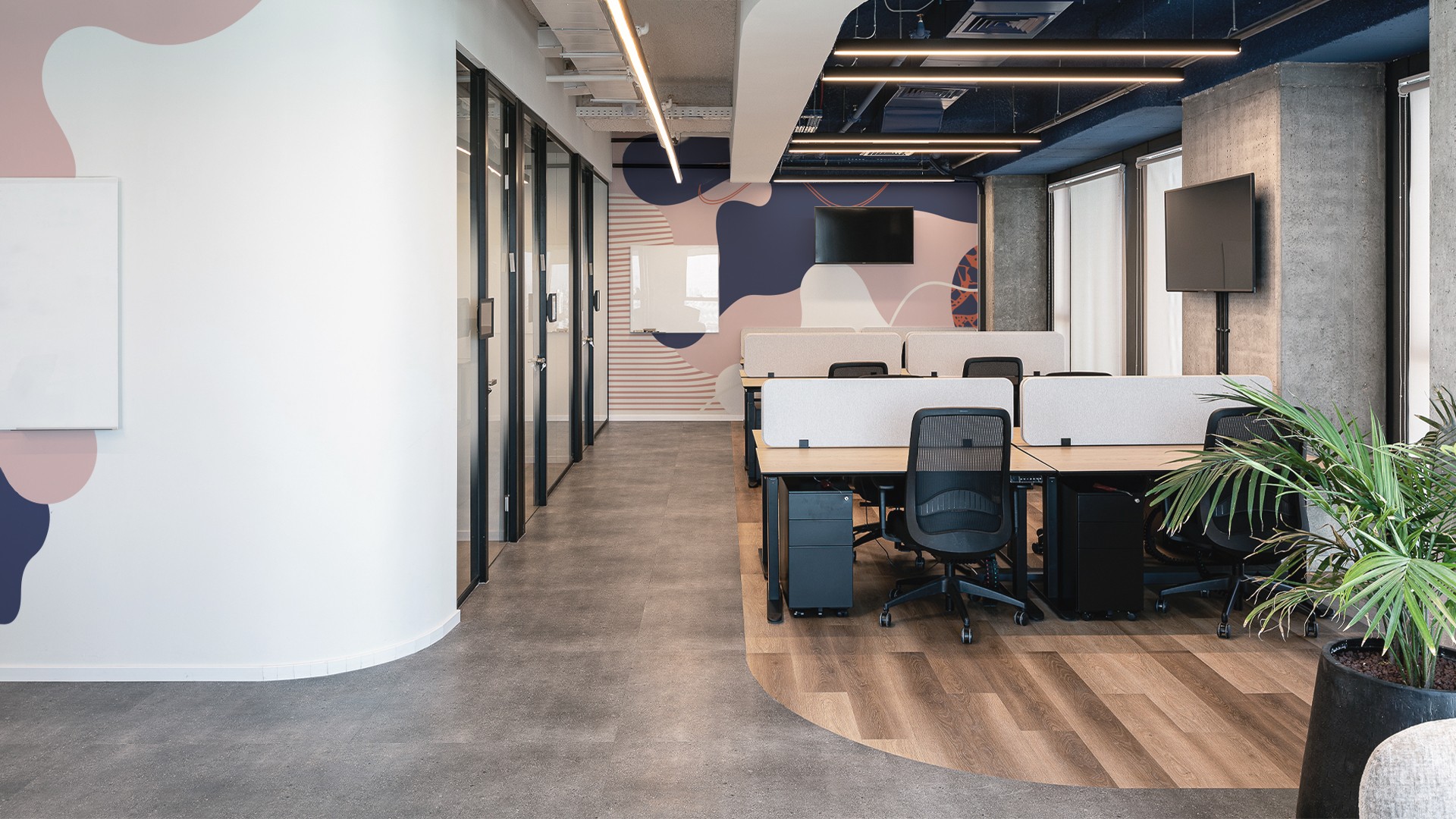 זרימה ושקיפות: מבט לאורך המסדרון הראשי, המדגיש את השימוש במחיצות זכוכית מרצפה לתקרה המאפשרות חדירת אור טבעי לכל עומק המשרד.