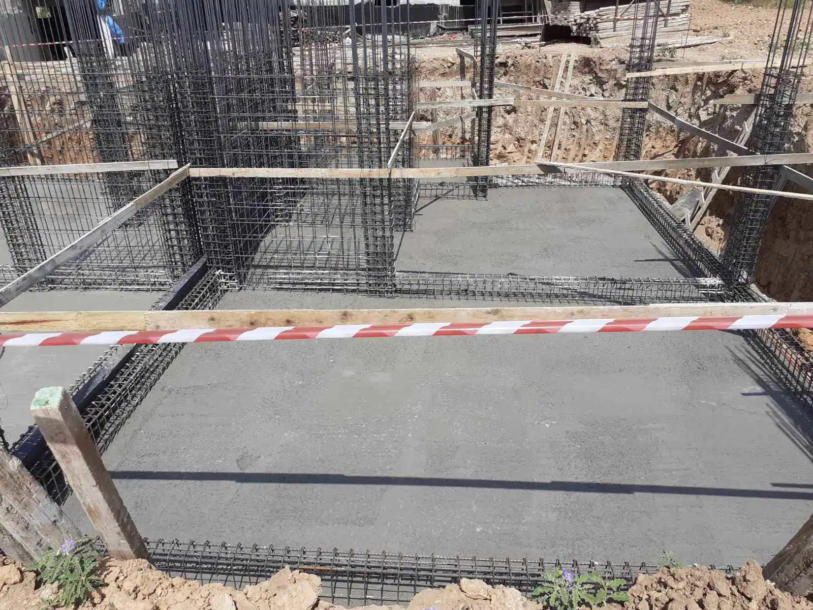 Φρέσκο σκυρόδεμα στη βάση θεμελίωσης με πυκνό σιδερένιο οπλισμό σε εργοτάξιο οικοδομής.