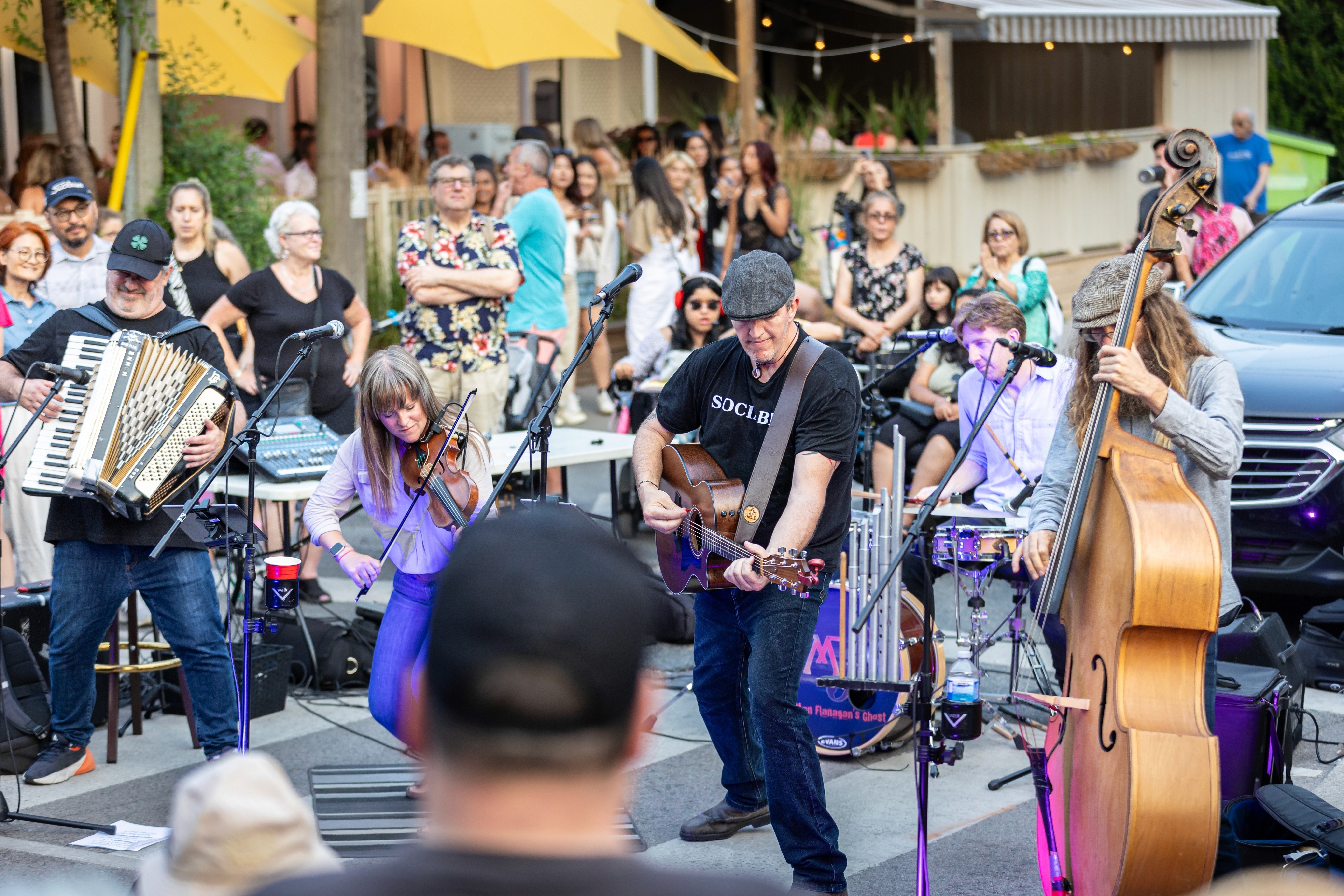 A local festival with a band playing to a scattered crowd.