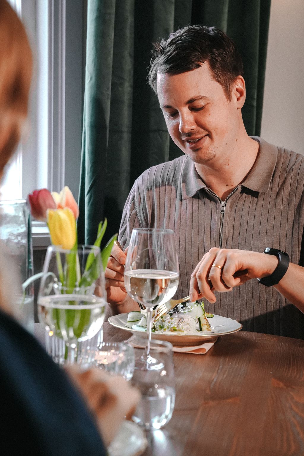 Person äter smörgås vid tebjudning