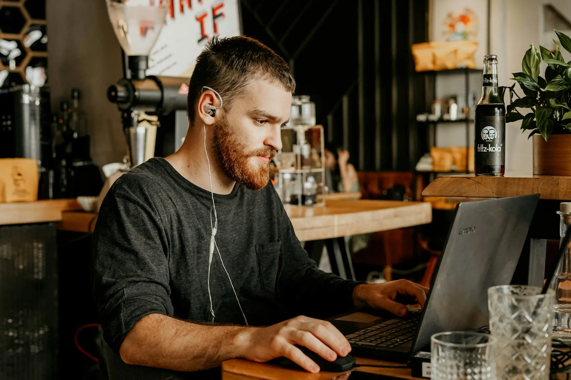 man in black crew neck t-shirt wearing black framed eyeglasses using computer