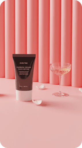 Carbon Cream Face Detox next to white rose petals and champagne glass with pink curtains