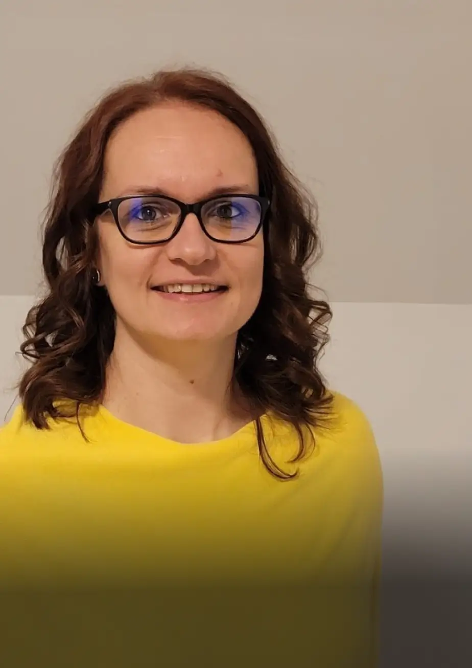 A smiling woman dressed with a yellow t-shirt