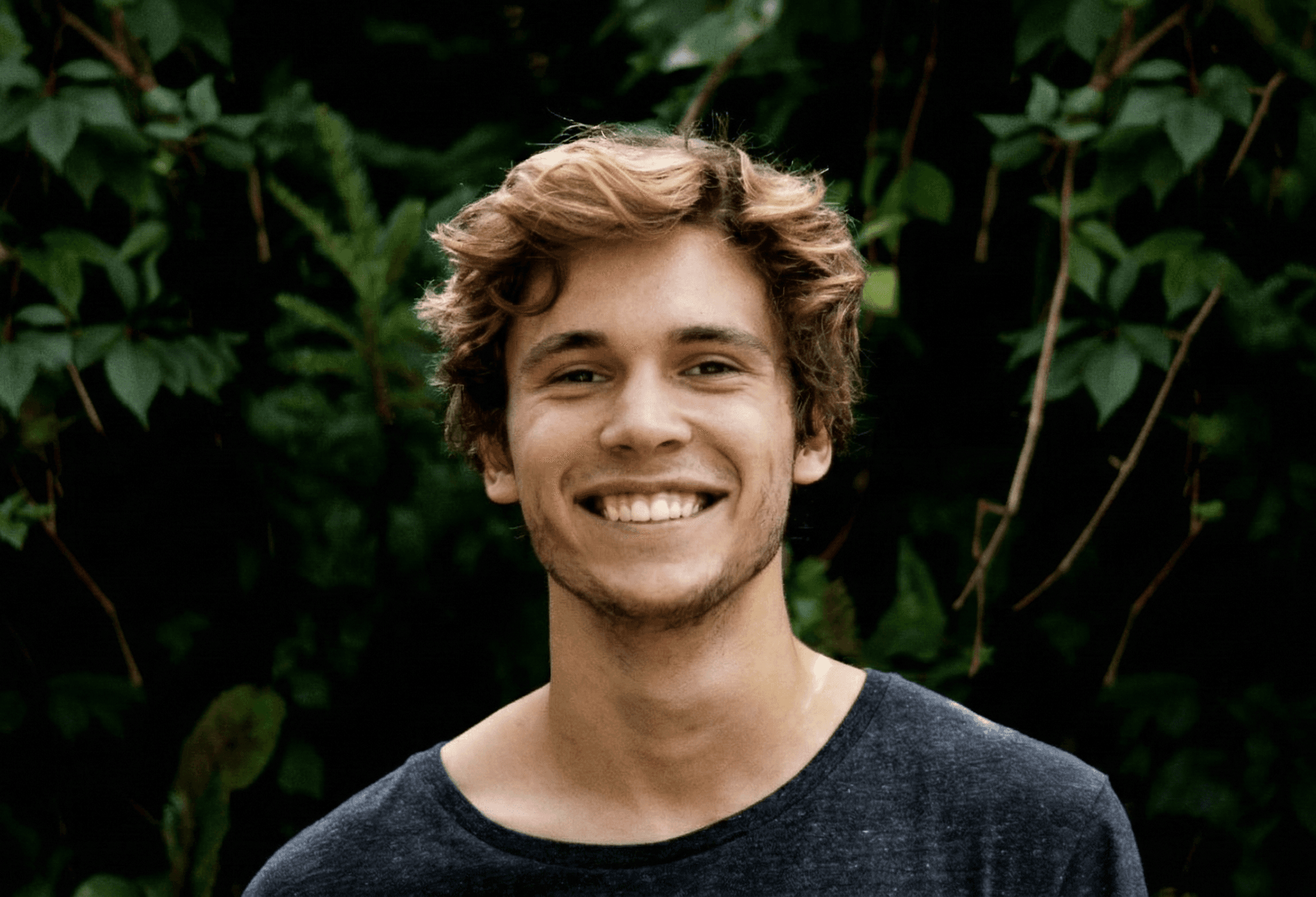 Smiling person portrait outdoors with greenery