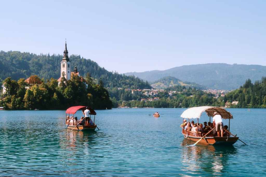 rowing boats on lake bled with bled church in the background