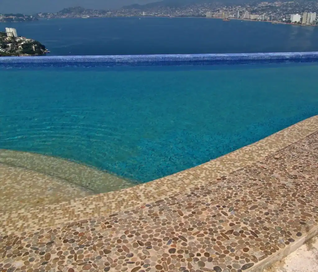 Detail of river rock coping against the mosaic waterline — Mosaiclegs Art Studio